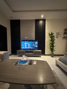 شقة أنيقة في العليا في الرياض: غرفة معيشة مع طاولة قهوة وتلفزيون