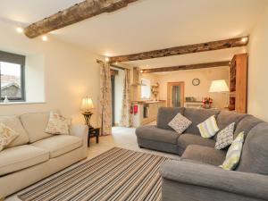 a living room with a couch and a table at Chequers Barn in Corsham