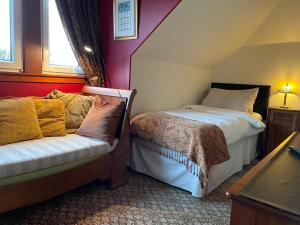 a bedroom with two beds and a couch in it at Ramadale B&B in Stornoway