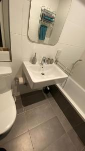 bagno con lavandino, servizi igienici e specchio di St. Julian's Super Bright And Spacious Seaview Apartment a San Giuliano