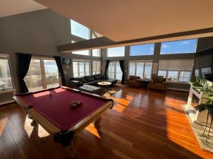 una gran sala de estar con una mesa de billar. en Spectacular home with a amazing ocean - river view, en Groton