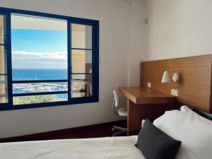 een hotelkamer met een bed en een groot raam bij VILLA RAMIMEDI - Vistas al mar in Puerto del Carmen