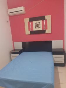 a bedroom with a bed and a red wall at Flat Amarração 130 in Luis Correia