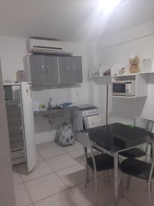 a small kitchen with a table and a refrigerator at Flat Amarração 130 in Luis Correia