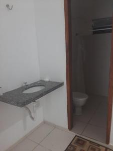 a bathroom with a sink and a toilet at Flat Amarração 130 in Luis Correia