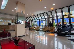 a lobby with chairs and tables in a building at Hotel Nacional Inn Curitiba Torres in Curitiba