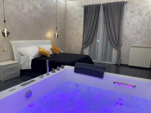 a room with a bed and a tub with purple lights at Green Oasis Gabella in Castelforte