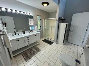 ein Badezimmer mit zwei Waschbecken, einer Dusche und einem WC in der Unterkunft Spectacular home with a amazing ocean - river view in Groton