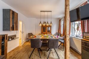 Il comprend une cuisine et une salle à manger avec une table et des chaises en bois. dans l'établissement Ferienhaus Bavaria WR - Ferienwohnung Servus, à Wernigerode