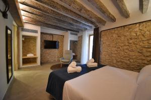 a bedroom with a bed and a stone wall at Calvario Plaza Hotel in Pollença