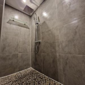 a bathroom with a shower with a stone floor at Moorparadies FRI-Südliches Friesland in Bockhorn