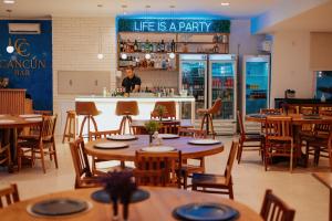 a man standing behind a bar in a restaurant at Casa Cancun Hotel Boutique & Eventos in Penha