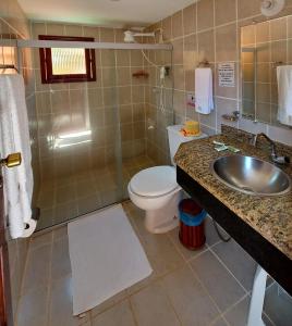 a bathroom with a toilet and a sink and a shower at Pousada É in Cumuruxatiba