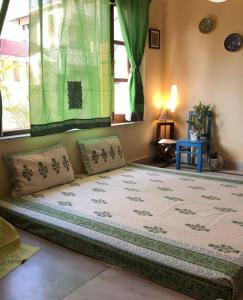 ein großes Bett in einem Zimmer mit Fenster in der Unterkunft Traveller's Nest in Shiliguri