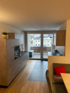 a kitchen with stainless steel appliances and a living room at Haus Ruach in Sillian