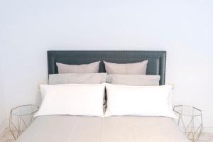 1 cama con almohadas blancas en un dormitorio blanco en Nordic apartment Sagrada Familia, en Barcelona
