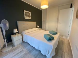 una camera da letto con un letto con due asciugamani sopra di torry de yomely sea view a Playa de las Americas