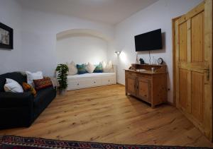 a living room with a couch and a tv at Altstadt Apartment am Schergentor in Hall in Tirol