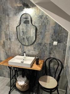 La salle de bains est pourvue d'un lavabo, de 2 chaises et d'un miroir. dans l'établissement BergOase-Apart am Feldberg, à Feldberg