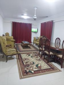 sala de estar con sillas, mesa y alfombra en شقة مصيفية للايجار, en Alejandría