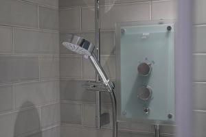 a shower with a shower head in a bathroom at Finnieston Apartment in Glasgow