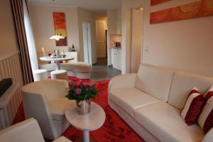 a living room with a white couch and a table at Suiten-Hotel mare Langeoog in Langeoog