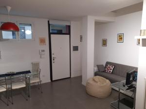 ein Wohnzimmer mit einem Sofa und einem Tisch in der Unterkunft Dimora La Turrita in Bologna