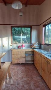 cocina grande con armarios de madera y ventana en Casa vista quebracho, en Puchuncaví