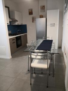 La cuisine est équipée d'une table, de chaises et d'un réfrigérateur. dans l'établissement Dimora La Turrita, à Bologne