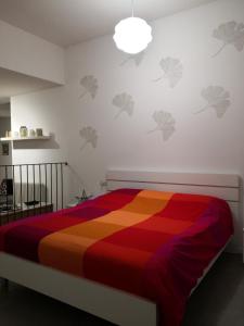 ein Schlafzimmer mit einem Bett mit einer bunten Decke in der Unterkunft Dimora La Turrita in Bologna