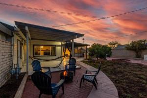 eine Gruppe von Stühlen, die um eine Feuerstelle auf einer Terrasse herum sitzen in der Unterkunft New Midtown Studio with Full Kitchen (Unit C) in Phoenix