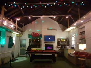 uma sala de estar com mesa de pingue-pongue e luzes em Big fireplace aga hot tub wet room barn garage em Llanelli