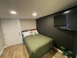 New Midtown Studio with Full Kitchen (Unit C) في فينكس: غرفة نوم صغيرة بها سرير وتلفزيون بشاشة مسطحة