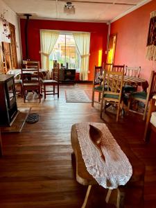sala de estar con mesa de madera y sillas en Hostal siete colores, Melipeuco en Melipeuco