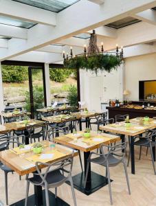 a restaurant with wooden tables and chairs and a chandelier at Agriturismo da Mamma in Alba