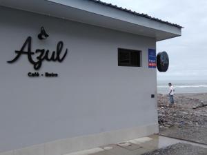 a man stands in front of a building at the beach at Tramonto Boutique Hotel in La Ceiba