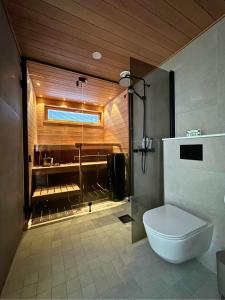 a bathroom with a shower and a toilet in it at Pramea Apartments Kultaniemi in Kuopio