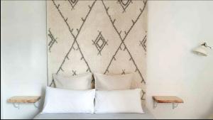 a bedroom with white pillows and a geometric wall at Nordic Apartment II Sagrada Familia in Barcelona