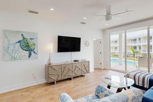 a living room with a tv and a couch and a table at Beach Club Tidal Wave #25 in Key Colony Beach