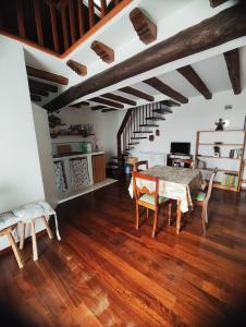 sala de estar con mesa y sillas y escalera en Chalet Romantico Sul Lago en Anguillara Sabazia