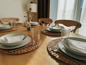 a wooden table with plates and dishes on it at Apartament a Palamós amb plaça de parking in Palamós