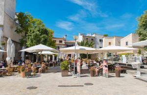 a group of people sitting at tables under umbrellas at Calvario Plaza Hotel in Pollença