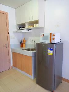 a small kitchen with a sink and a refrigerator at Ace That Condo Staycation Cheer Residences beside SM Marilao in Marilao