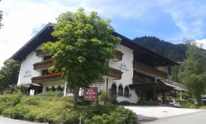 a white building with a tree in front of it at Hotel Moawirt in Wagrain