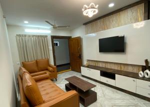 a living room with a couch and a flat screen tv at Ahasa Bacardi in Hyderabad