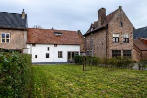 een lege tuin voor een groot bakstenen gebouw bij Begijnhof 9 in Sint-Truiden