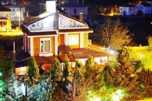 a white house with a roof at night at BUTTERFLY BOUTIQUE HOTEL AĞVA in Sile