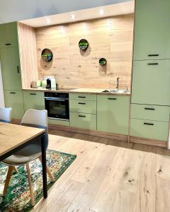 uma cozinha com armários verdes, uma mesa e um lavatório em H-36 RESIDENCE 0.1 em Koblenz