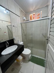 a bathroom with a sink and a toilet and a shower at Pousada Sapê in Praia do Frances