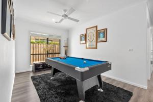 a pool table in a living room with a ceiling fan at Nirvana Armstrong Creek Family Beach Home in Mount Duneed